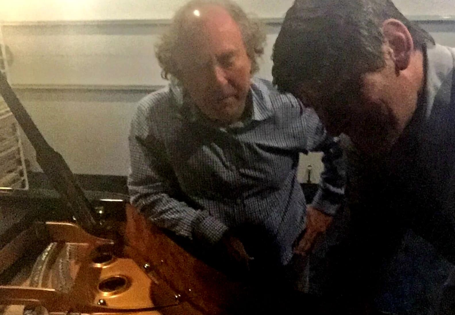 Jeffrey Kahane and Notes from the Fires host John Rabe reflected in the lid of Kahane’s Italian Fazioli piano, in a photo taken in his home studio in 2017.